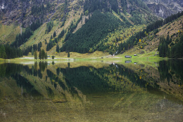 Calm alpine mountain lake with clear water reflection