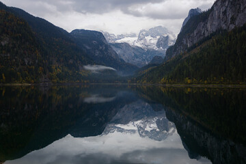 Fototapeta na wymiar Lake Gosau in Autumn with still water and the Dachstein mountain range in the background