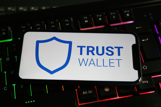 Viersen, Germany - January 9. 2022: Closeup Of Mobile Phone With Logo Lettering Of Bitcoin Trust Wallet Computer Keyboard