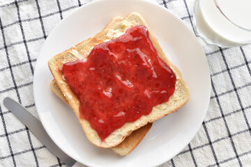 Toast with raspberry jam and butter on a plate.  Lovely breakfast at home.  Food from above concept.