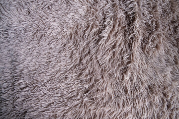 Fluffy plaid of polyester with a long heap gray. Comfortable home textiles. Background, texture