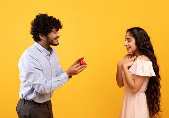 Marry me concept. Happy indian man proposing showing engagement ring box and asking girlfriend to...