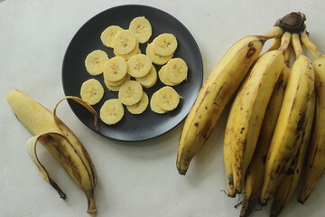 Ripe plantain yellow in colour and thin round plantain slices, - obrazy, fototapety, plakaty