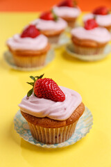 Natural strawberry cupcake and cream on yellow background