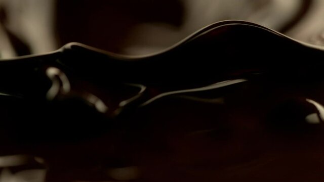 Super slow motion of dark hot chocolate splashing, close-up. Filmed on high speed cinema camera, 1000fps.