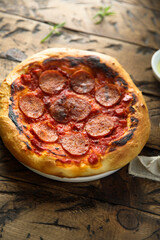 Traditional pepperoni pizza on the wooden desk