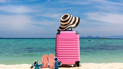 Fototapeta na wymiar Summer stuff with Pink luggage on the white sand Beach background banner of the tropical travel concept