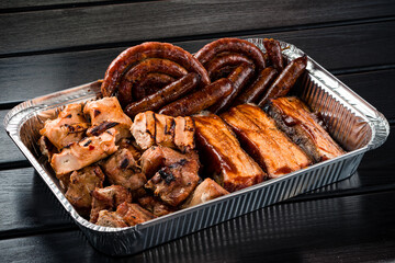 set of grilled ribs and BBQ meat in a delivery box