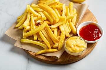 Close up of potatoes fries and cheese and ketchup sauces