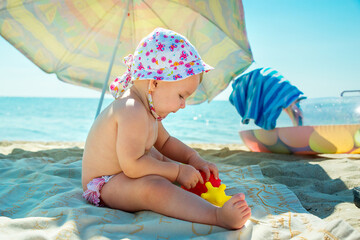 Children play on a tropical beach. Children play on the sea on summer family vacation. Sand and water toys, sun protection for small children.