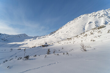 Mountain winter landscape in the Tatras, trail trampled in the snow overlooking the snow-capped mountains in frosty sunny weather Tatras Poland