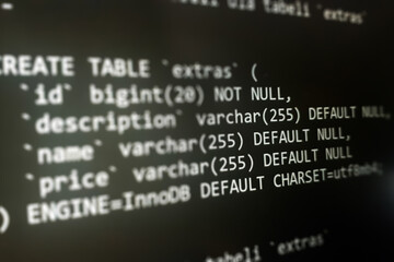 Structured sql code on monitor. SQL code on a dark background development concept