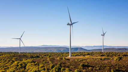 Wind turbines on a beautiful blue sky in a mountain wind farm in Sardinia. Renewable energy...
