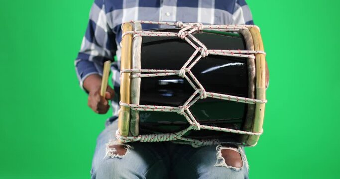 young dominican man playing tambora merengue on green screen
