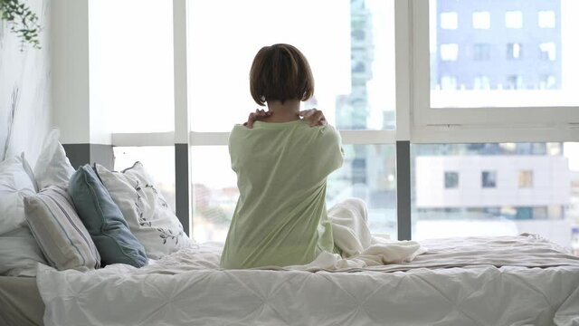 Neck pain, woman suffering from backache in the bedroom, health problems concept