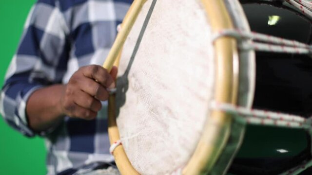 young dominican man playing tambora merengue on green screen