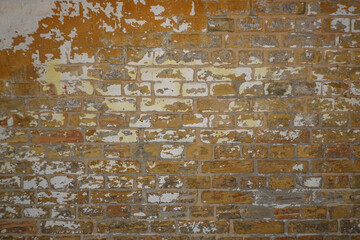 Destroyed Concrete and Brick wall. Background of old vintage dirty brick wall with peeling plaster, texture, torn brick wall background. Old Grungy Brick Wall Horizontal Texture. Brickwall Backdrop.