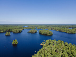 Aerial view of blue lakes and green forests on a sunny summer day in Finland. Drone photography. Ecosystem and healthy environment concepts and background...
