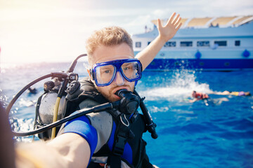 Selfie photo man diver scuba diving blue water sea looking at camera with sun light. Concept travel...