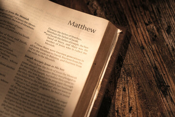 open bible on wooden table, chapter Matthew. contrast atmosphere - obrazy, fototapety, plakaty