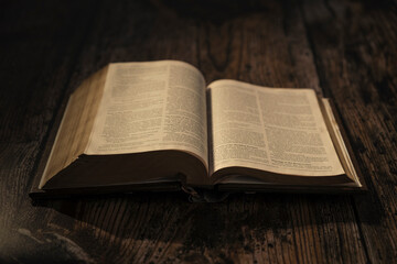 Fototapeta premium open bible on wooden table, chapter Matthew. contrast atmosphere
