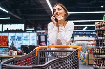 Woman shopping at the grocery store and talking on phone