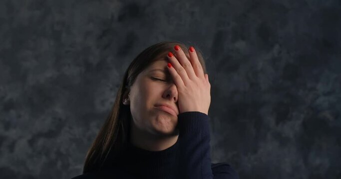 Actor woman does facepalm move in studio on the dark background, 4k 60p Prores