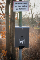  container for dog waste bags is attached to a pole