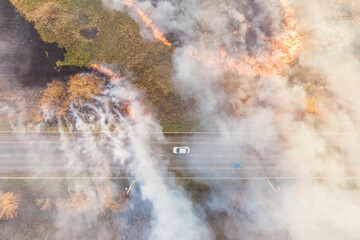 Fototapeta na wymiar spring dry grass fire next to a busy highway; photo taken from a drone