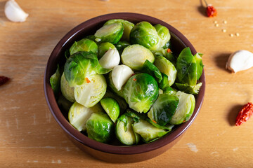 Brusselle spout with garlic on a wooden background.