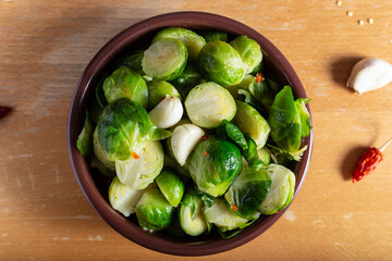 Brusselle spout with garlic on a wooden background.