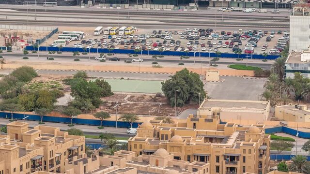 Aerial view of a parking lot with many cars behind a blue fence timelapse