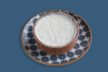A crock of Buffalo yogurt with lots of cream on it on a vintage plate. Güveçte Manda yoğurdu.  A delicious crock of buffalo yogurt on a stylish round plate.  greek yoghurt