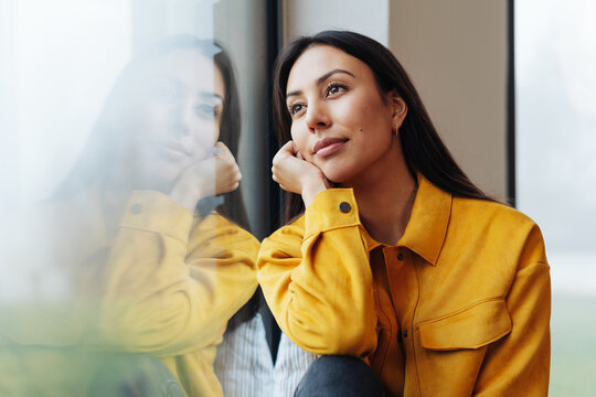 Pensive young woman staring out of a window
