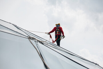 Male workers rope access height safety connecting with a knot safety harness, to ascending,...