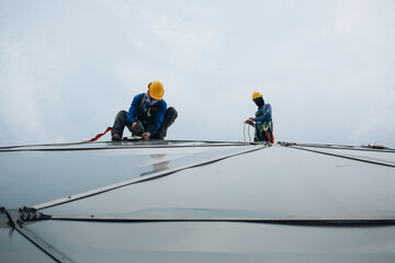 Male workers rope access height safety connecting with a knot safety harness, to ascending, construction site oil tank dome.