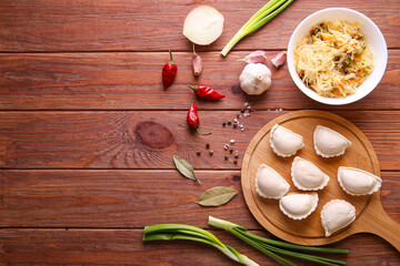 Raw dumplings with cabbage on a wooden background with place for text