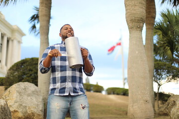 dominican man playing merengue guira with dominican flag - obrazy, fototapety, plakaty