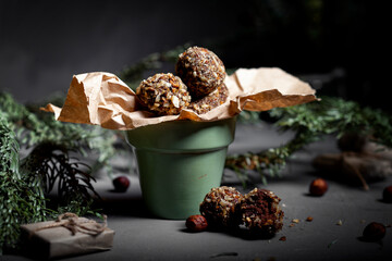 Chocolate truffle with hazelnut topping. Against the background of Christmas trees.
