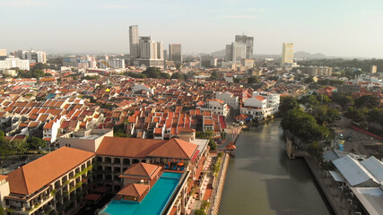 Fototapeta premium Melaka, Malaysia. Aerial view of city homes, river and skyline from drone on a clear sunny day.