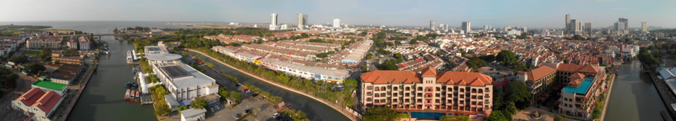 Naklejka na ściany i meble Malacca, Malaysia. Panoramic aerial view of city skyline and river from drone on a hot sunny day