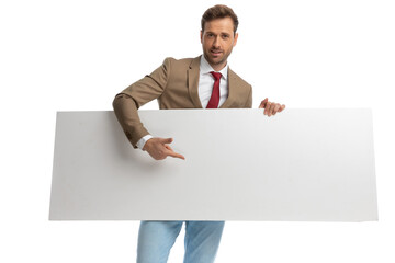 attractive businessman pointing his finger at his orizontal board