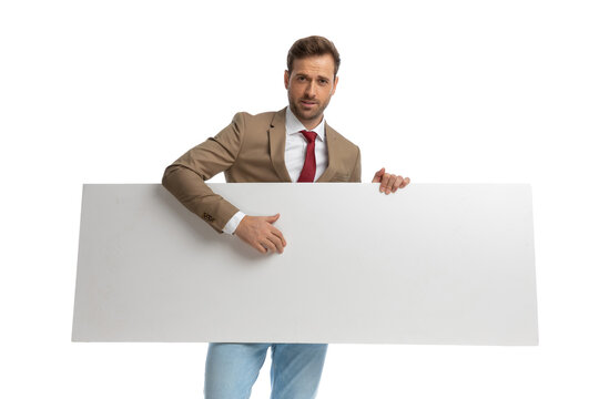 attractive businessman showing his blank board at the camera