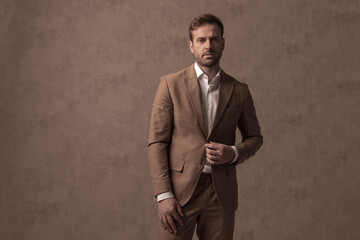 young handsome businessman arranging his jacket and posing