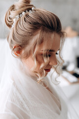 Beautiful hairstyle of the bride. Jewelry in the hair. The morning of the bride. Preparing for the ceremony.