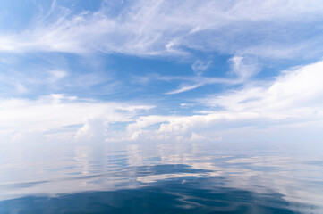 Blue sky and white fluffy clouds with reflect on sea background and pattern