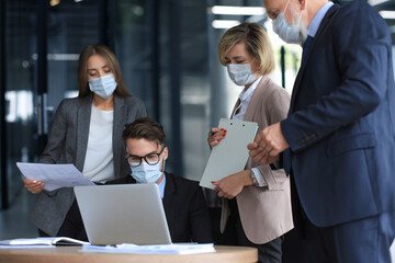 Business people wearing protective face masks while holding a presentation on a meeting during...