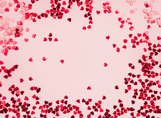 Fototapeta na wymiar Frame of small red hearts on a pink background. Valentine's Day. Layout design for text. Copy space.