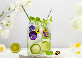 Cold Infused detox water with edible flowers,lime and mint leaves. Refreshing summer drink.
