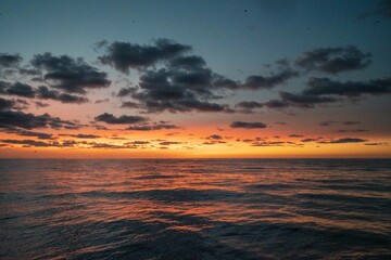 Obraz premium Calm golden sunset on open water while sailing the atlantic ocean